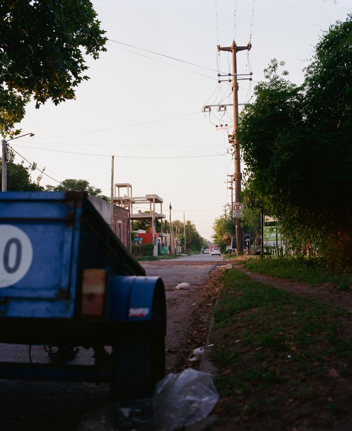 A serene suburban street scene at dusk featuring a parked vehicle trailer and power lines.
